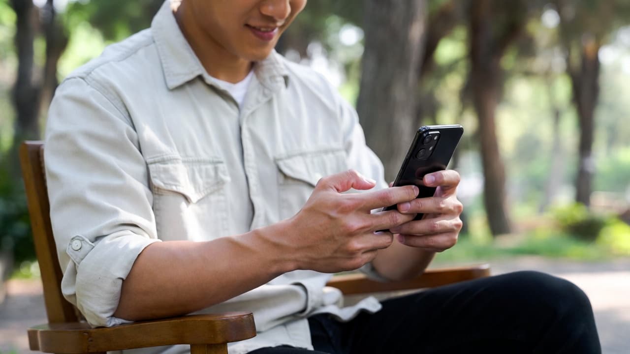 Freelancer tracking work time on smartphone outdoors