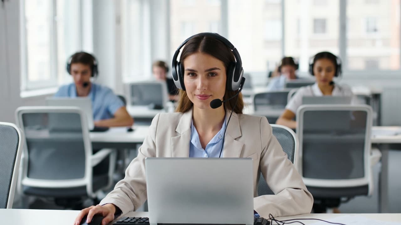Call center agent with headset using time tracking on laptop